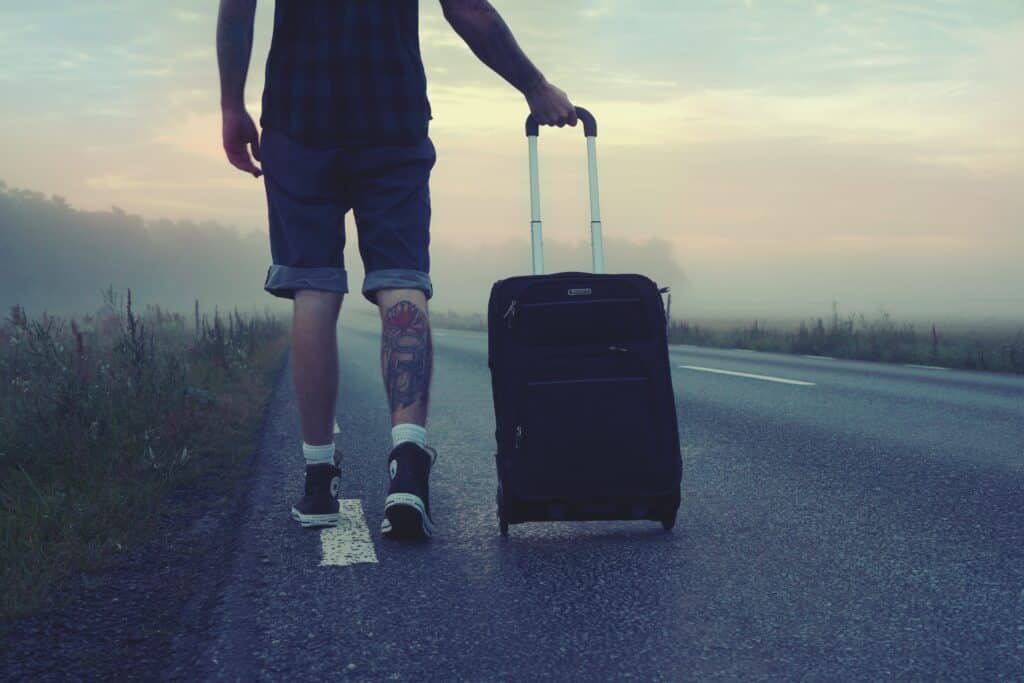 Rejsende mand som går med en kuffert i udlandet